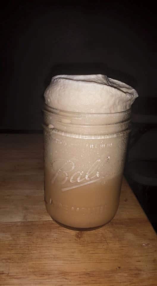 mason jar filled with rootbeer and whipped foam on top